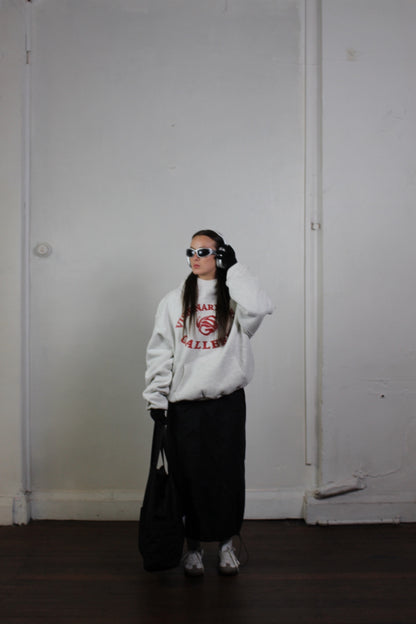 Model posing with Vision studios' Visionary art gallerie hoodie in marl grey and red (size M)