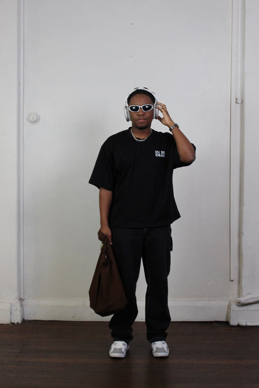 Front view of model wearing black oversized drop shoulder t-shirt featuring distressed thumbprint graphic inspired by Genesis 1:26-27