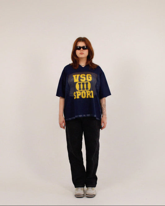 Person wearing a navy blue t-shirt with yellow text on a white background