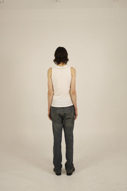 Full body view of the back of a white ribbed tank top showing overall fit and length, paired with straight-leg denim jeans.