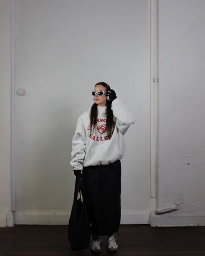 Model posing with Vision studios' Visionary art gallerie hoodie in marl grey and red (size M)