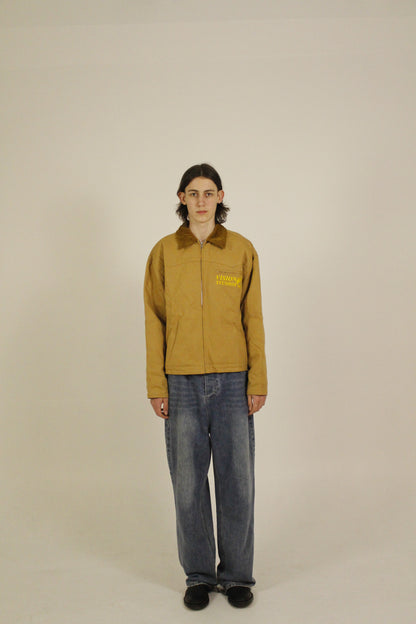 Side view of model wearing SAMPLE_001 canvas utility jacket zipped with embroidered Vision Studios logo, showing cropped workwear fit and structured silhouette